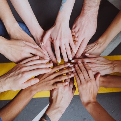 team putting their hands into a circle