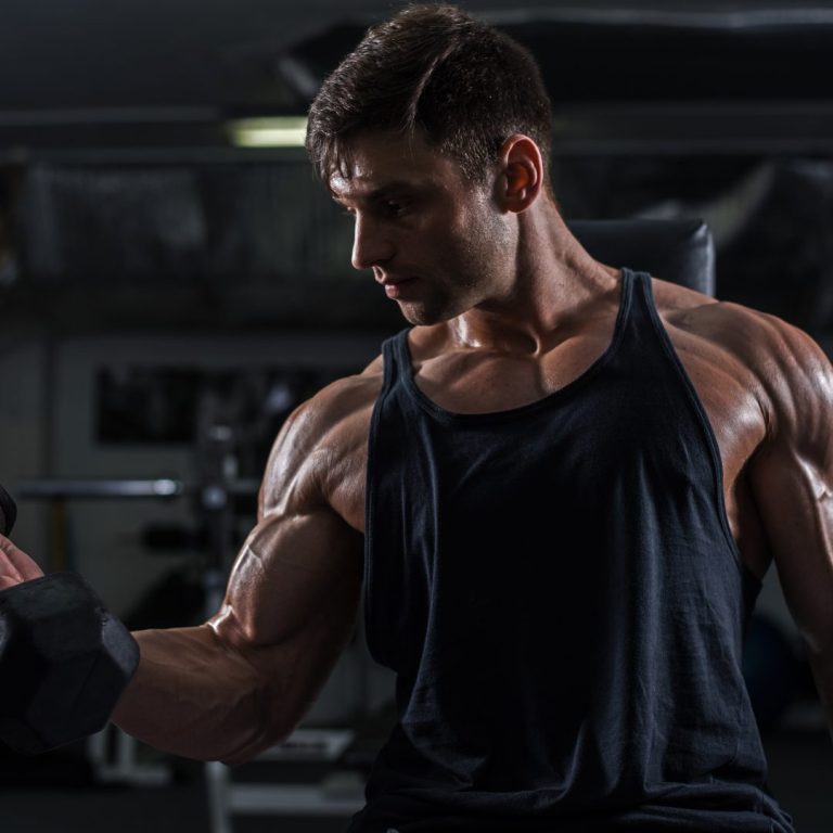 A man doing a rep during a set, symbolizing the cost of personal trainer insurance.