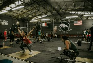People exercising in a gym, highlighting activities that could require different types of liability insurance for trainers or fitness professionals.