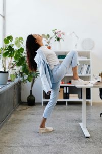 woman stretching over desk