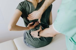 medical professional evaluating a woman's back pain
