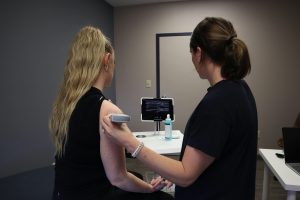 medical professional performing ultrasound on a woman's arm