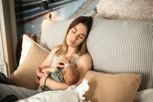 woman bottle feeding baby