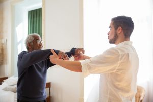 physical therapist guiding movement with male client