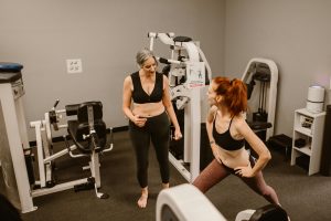 personal trainer demonstrating balance exercises for rehabilitation for her older adult client
